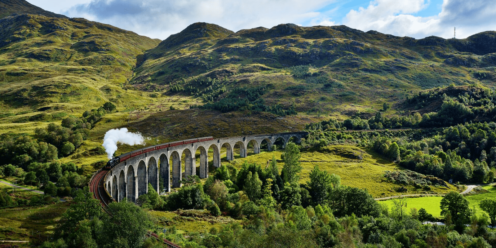 A train traveling over a bridge in the mountains
