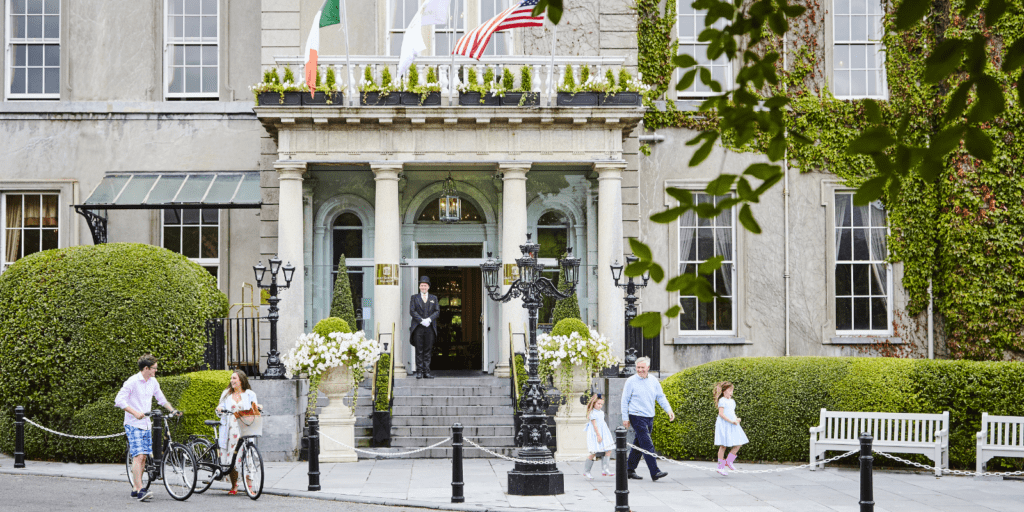 A group of people walking down a sidewalk next to a building