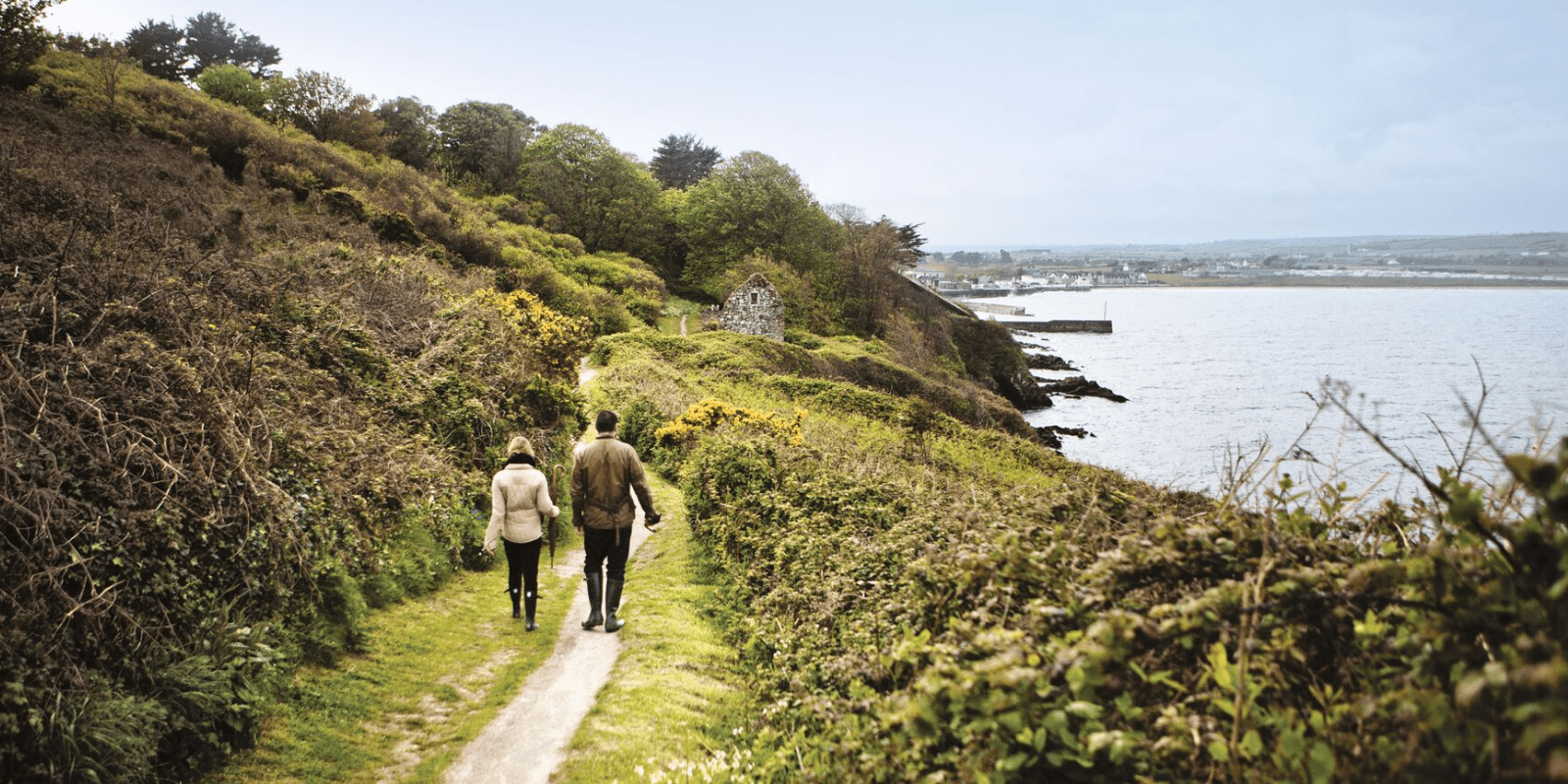 A couple of people that are walking down a path