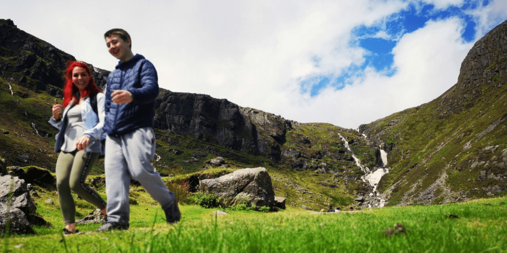 A man and a woman are walking in the mountains