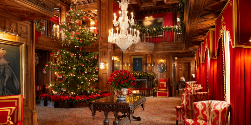 A room with a christmas tree and a chandelier