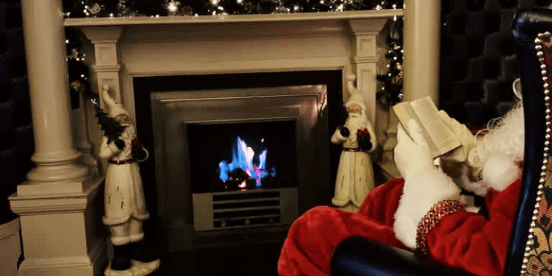Santa Claus sitting in a chair with a book in his hand