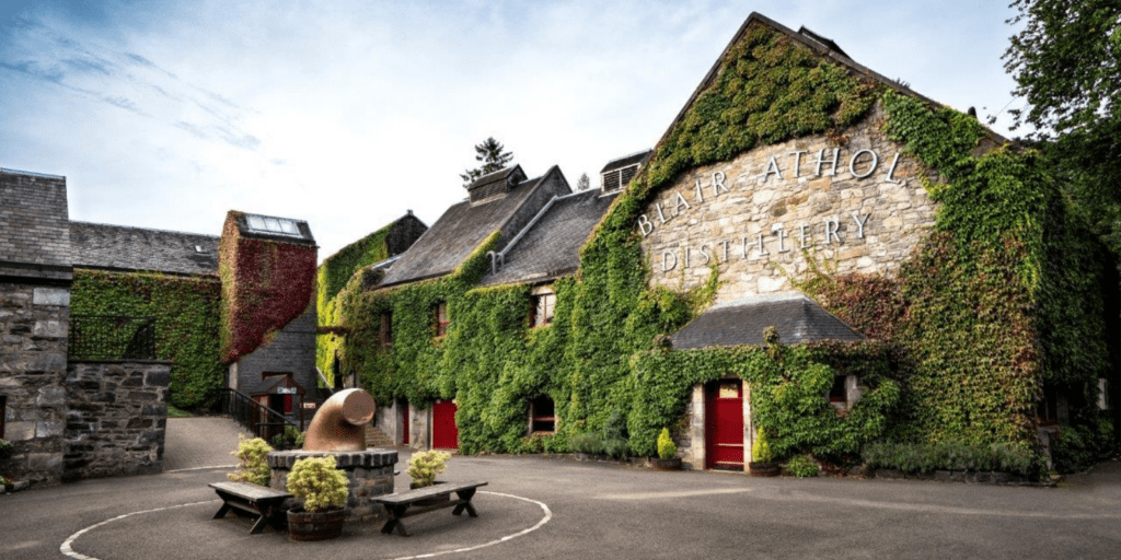 A building covered in vines with a bench in front of it