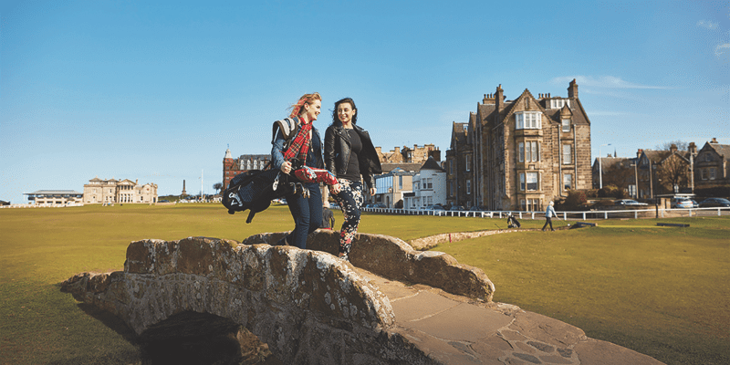 Women chatting when crossing a stone bridge