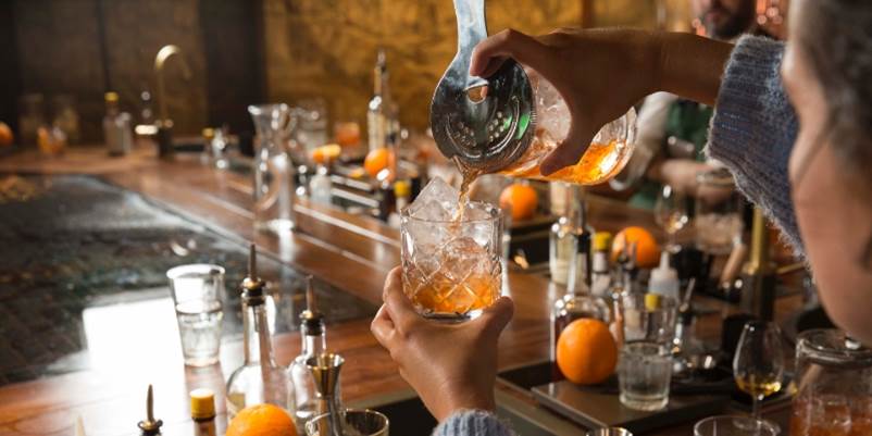 A person pouring a drink into a glass