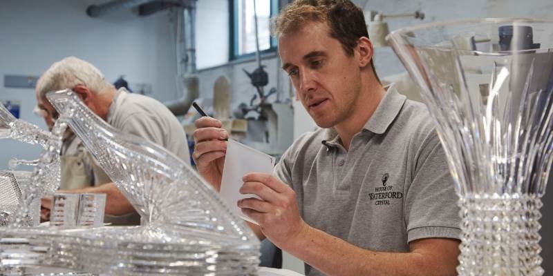 A man working on a glass sculpture in a shop