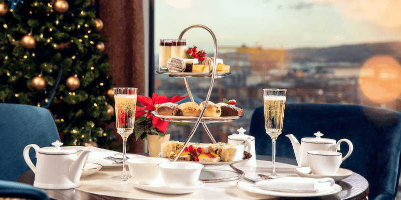 A table topped with a tray of food next to a christmas tree
