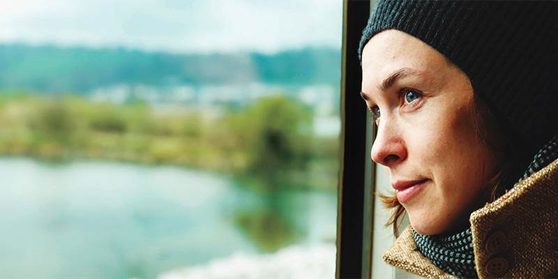 A woman looking out the window of a train