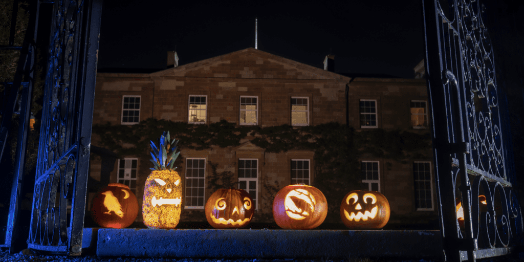 A group of carved pumpkins sitting in front of a building