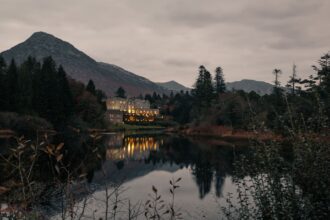 Ballynahinch Castle in winter, surrounded by trees under a dark, overcast sky