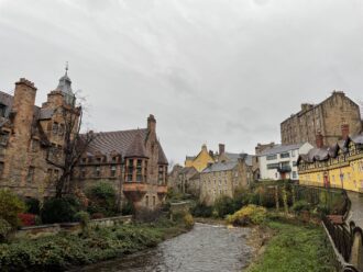 Historic red brick buildings in Edinburgh, Scotland in the neighborhood of Leith over a river.