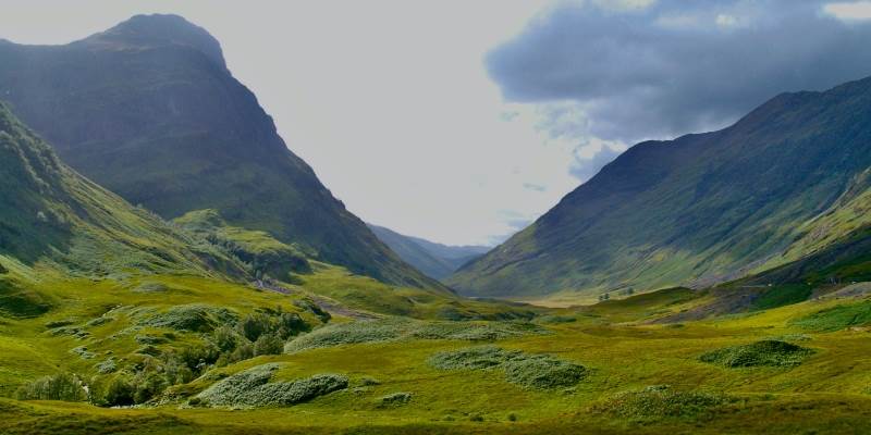 A green valley with mountains in the background