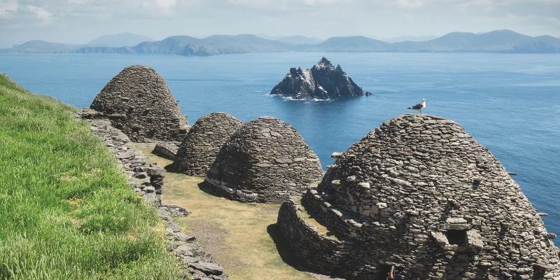 A group of rocks sitting on top of a lush green hillside