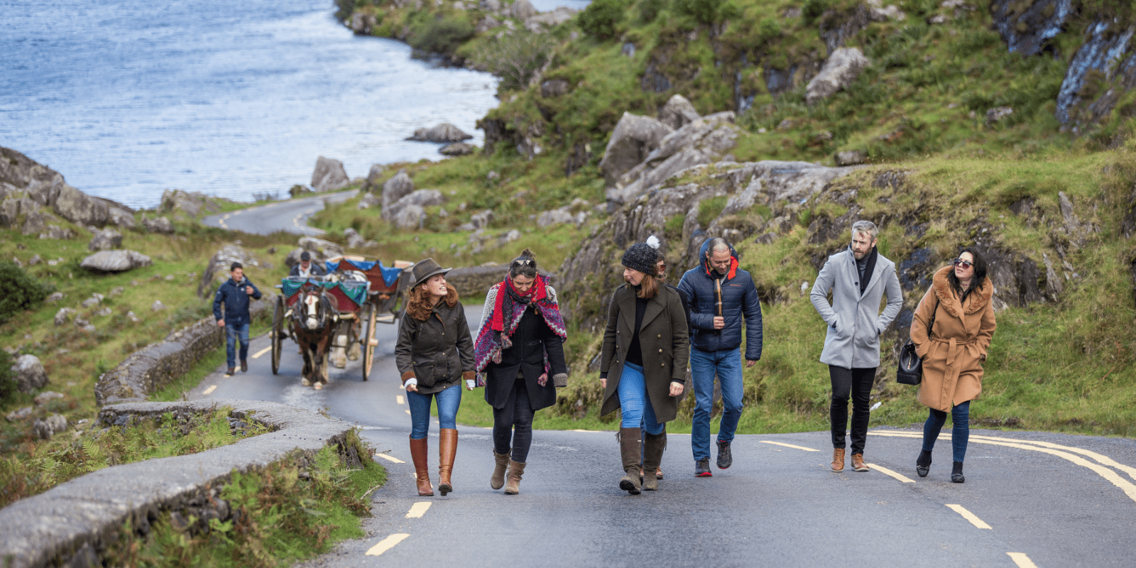 A group of people walking down a road in Killarney National Park
