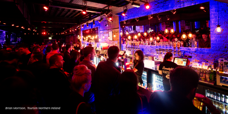 A group of people standing around a bar