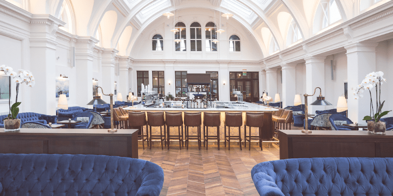 A large room with blue couches and tables