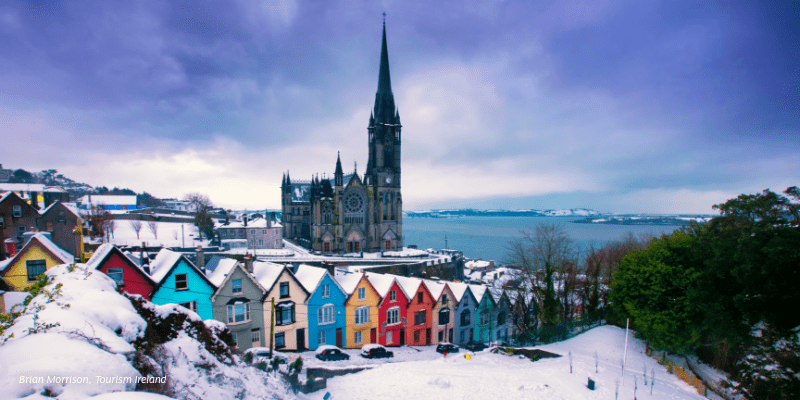 A snowy view of a city with a church in the background