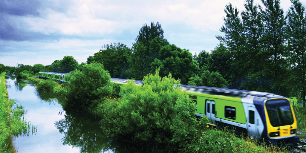 A train traveling down tracks next to a river