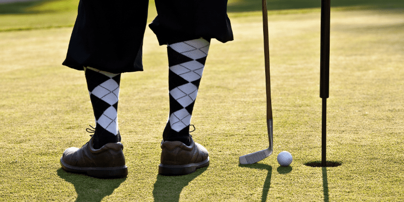 Golf player on a field next to a hole