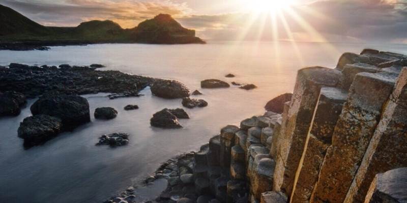 Giant's Causeway with the rising sun in the background
