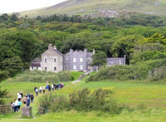Tourists on a walk towards a mansion in County Kerry, Ireland