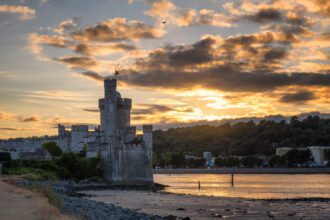 Blackrock Castle at sunset with ocean and trees in the background