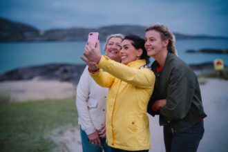Three women taking a selfie on a beach in Kerry, Ireland.