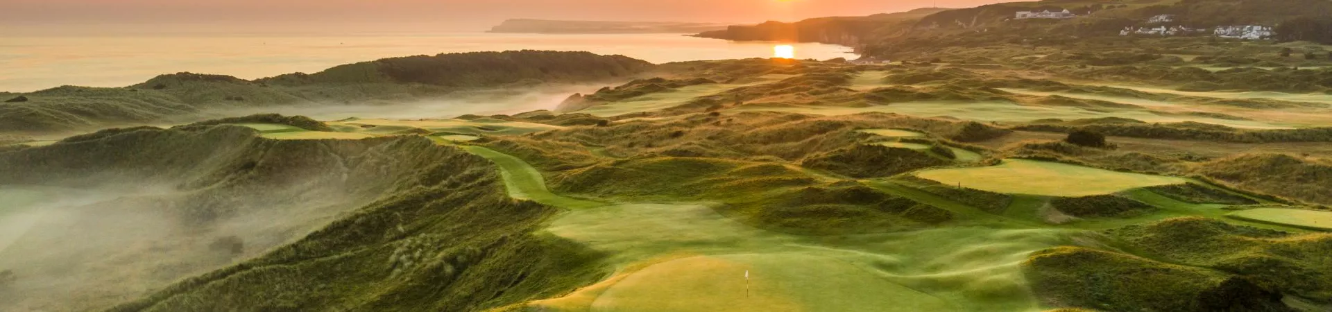 The sun is setting over a golf course