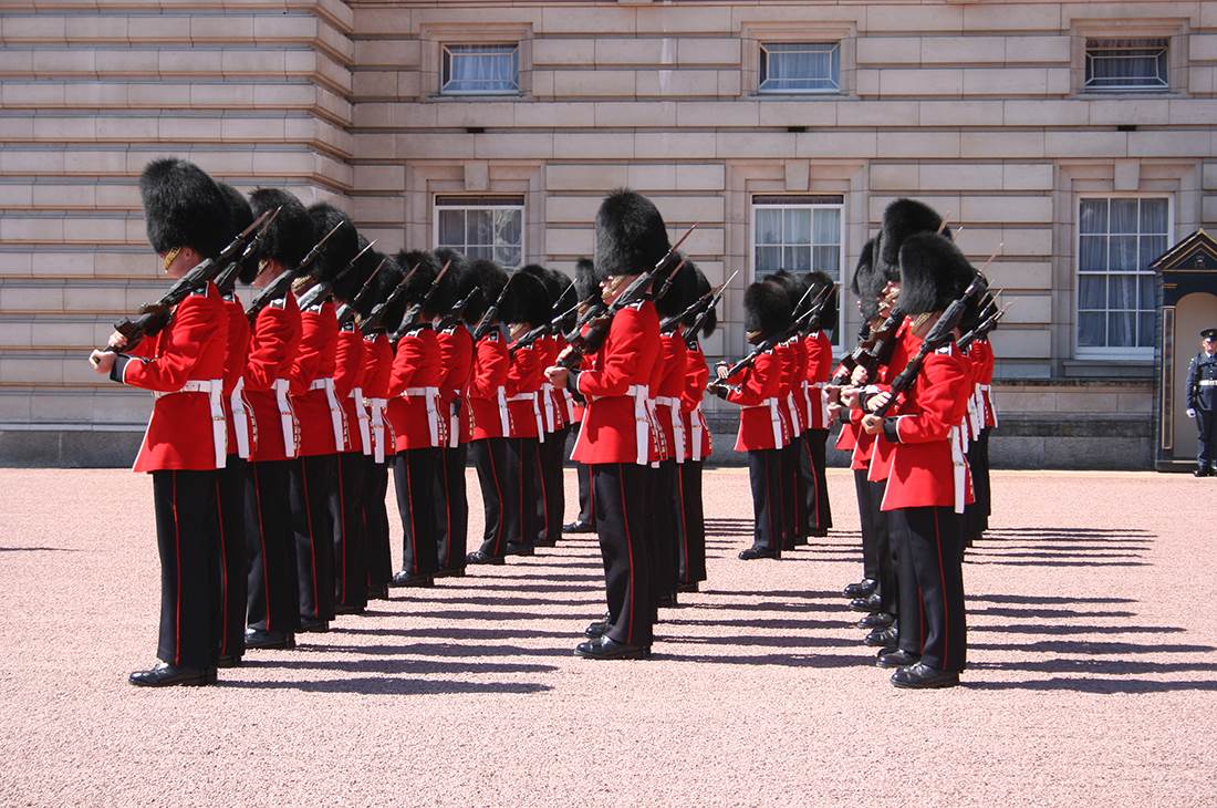 A group of men in red uniforms standing in front of a building 