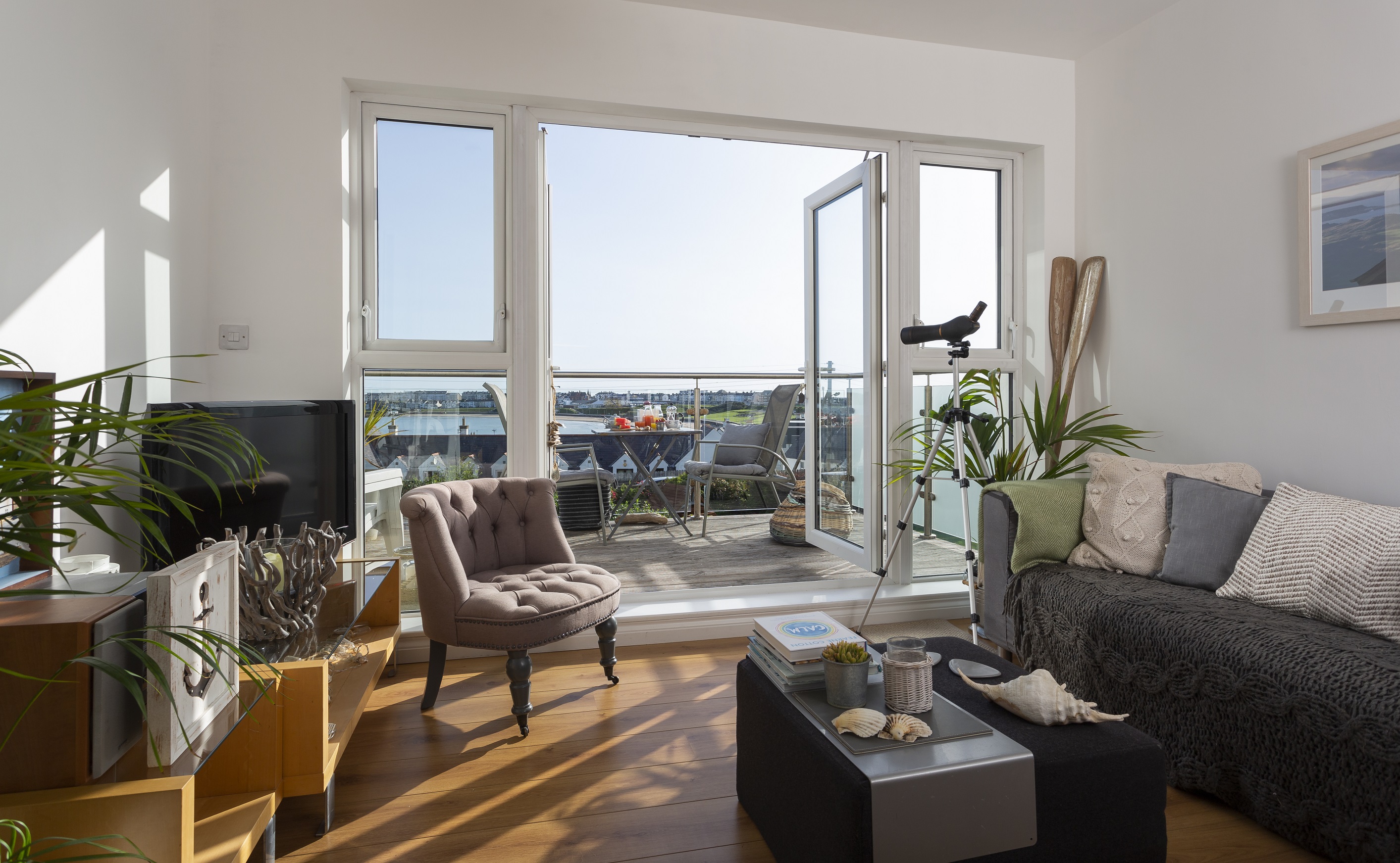 A room with balcony, sofa, chair and TV in Blackrock House in Portrush, Ireland