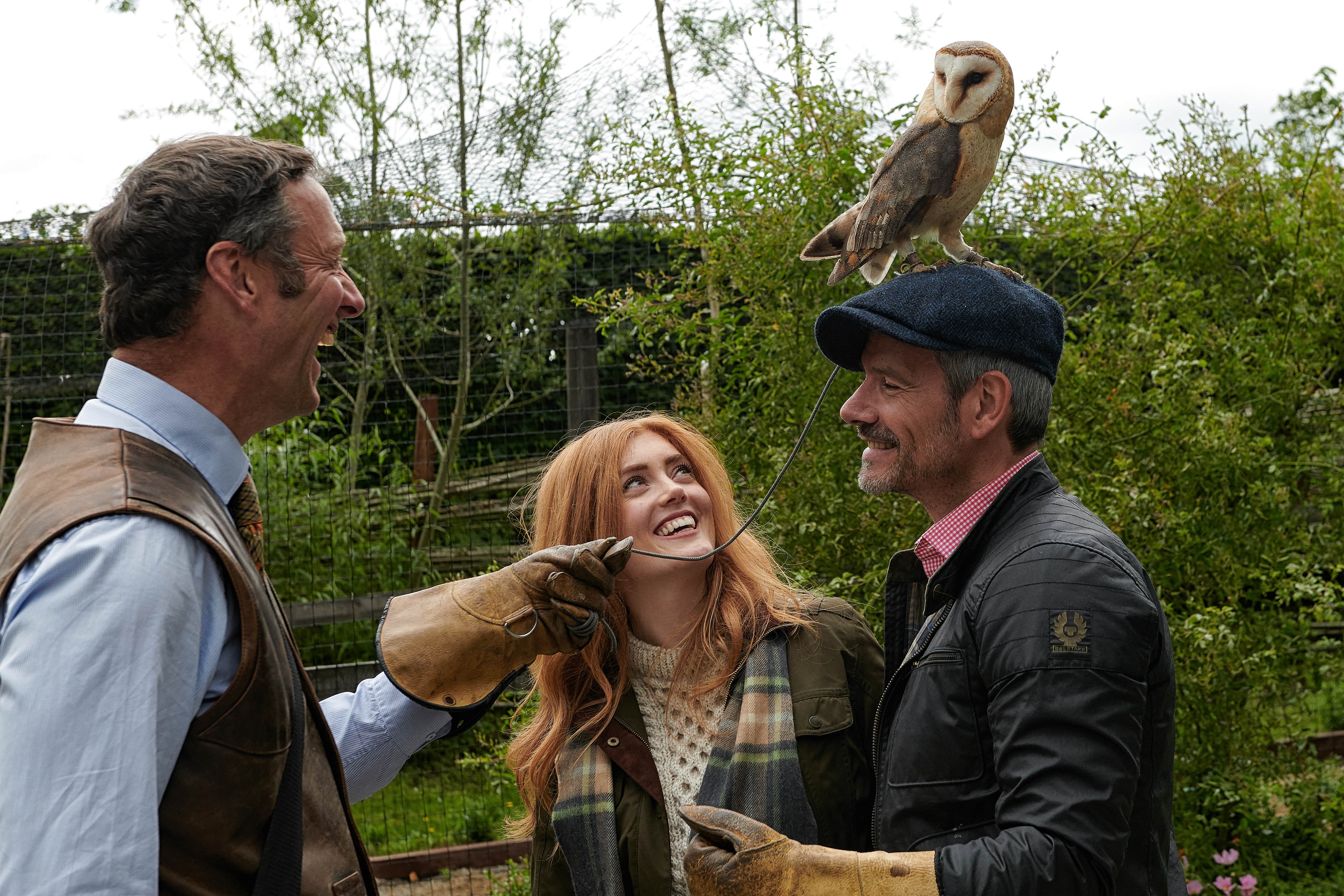 Two men and a woman enjoying falconry activity in Dromoland Castle