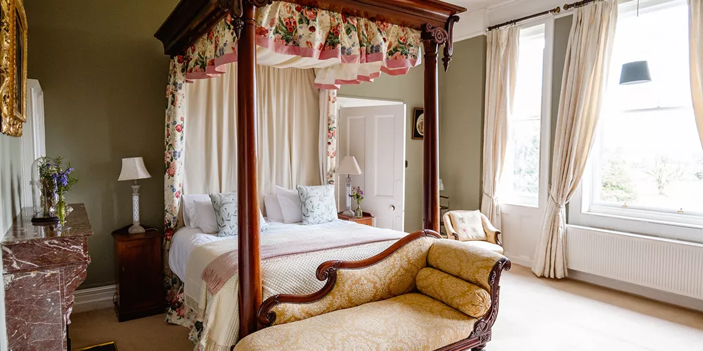 A bedroom with a four poster bed and a fireplace at Clonalis House in Roscommon