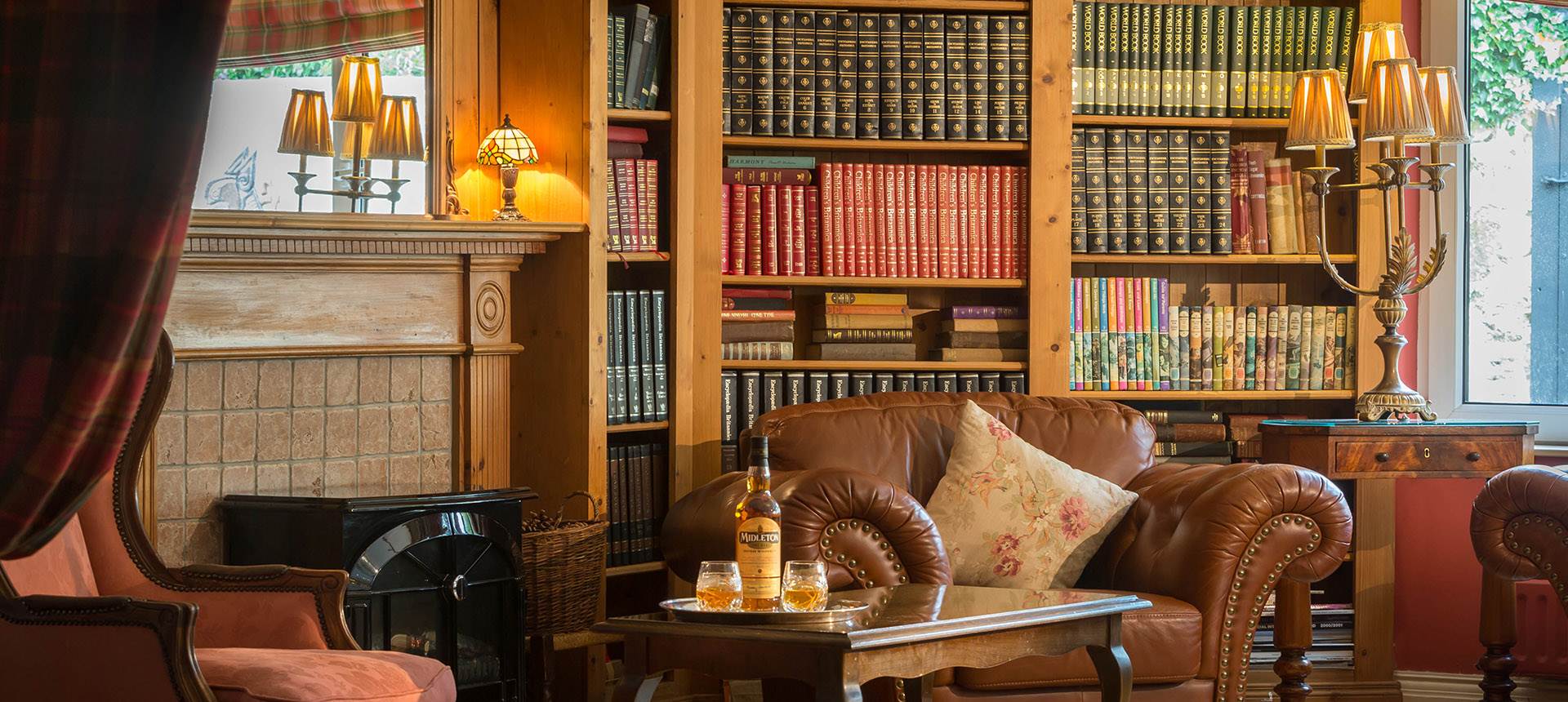 A library room filled with furniture and a fire place