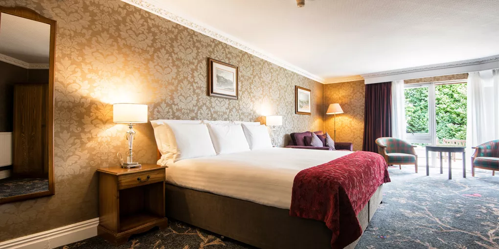 Classic studio with a large bed and floral wallpaper at Kingsmills Hotel, Inverness