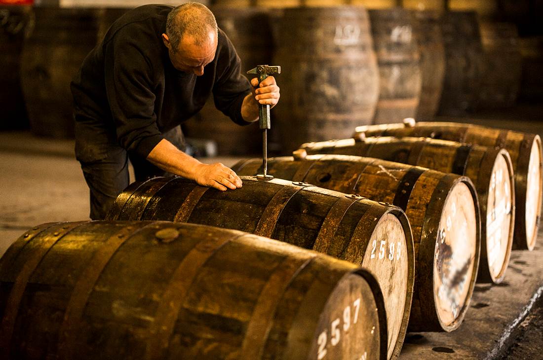 A man in a black shirt working with barrels 