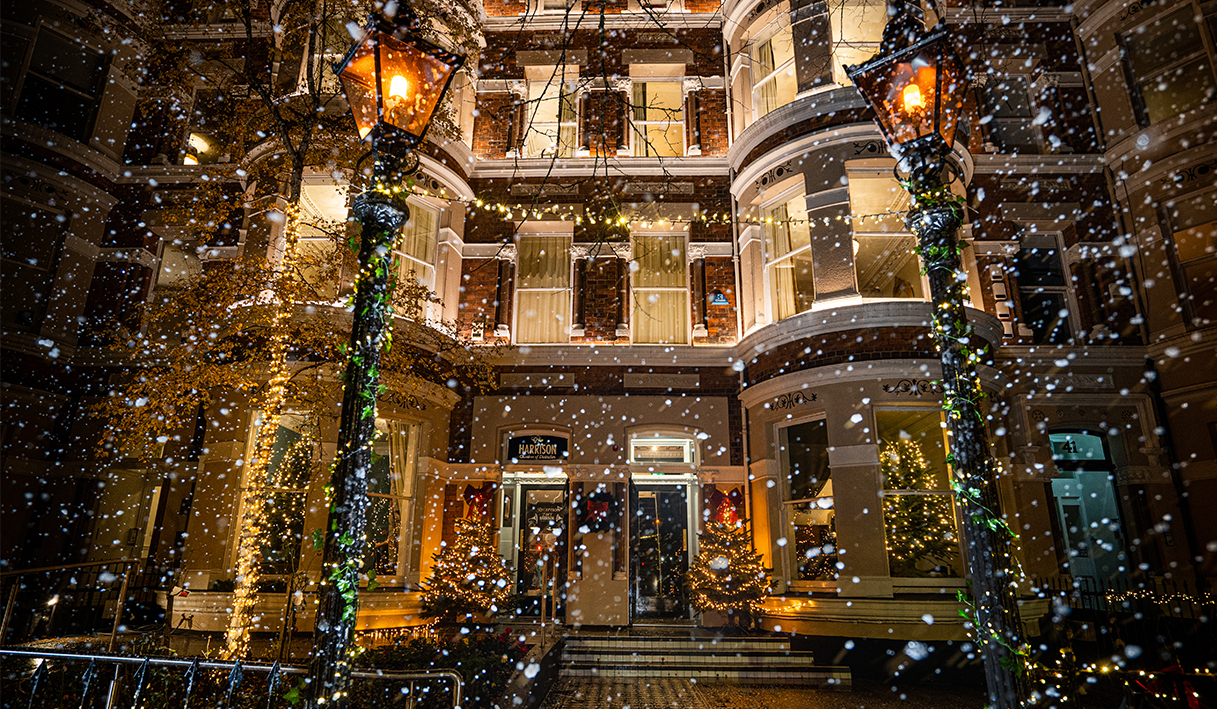 The front of the harrison hotel with snow falling