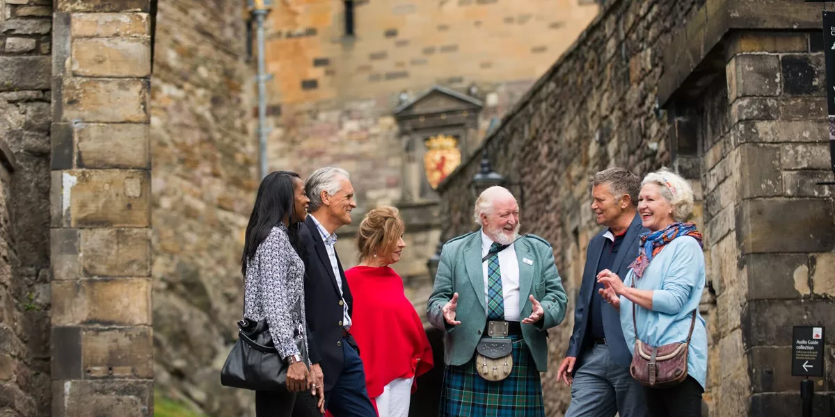 Tour guide in kilt addressing tourists