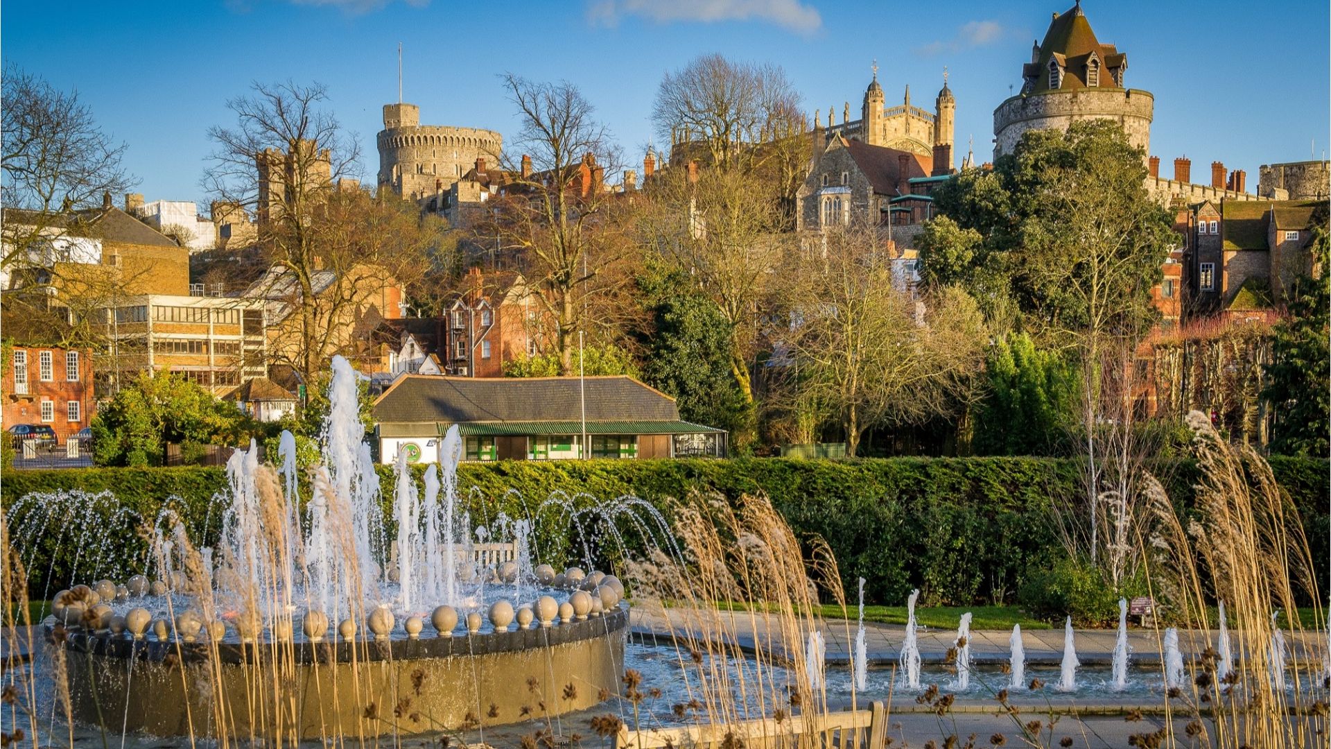 A fountain in a park with a castle in the background