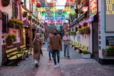 A group of people walking down a narrow street