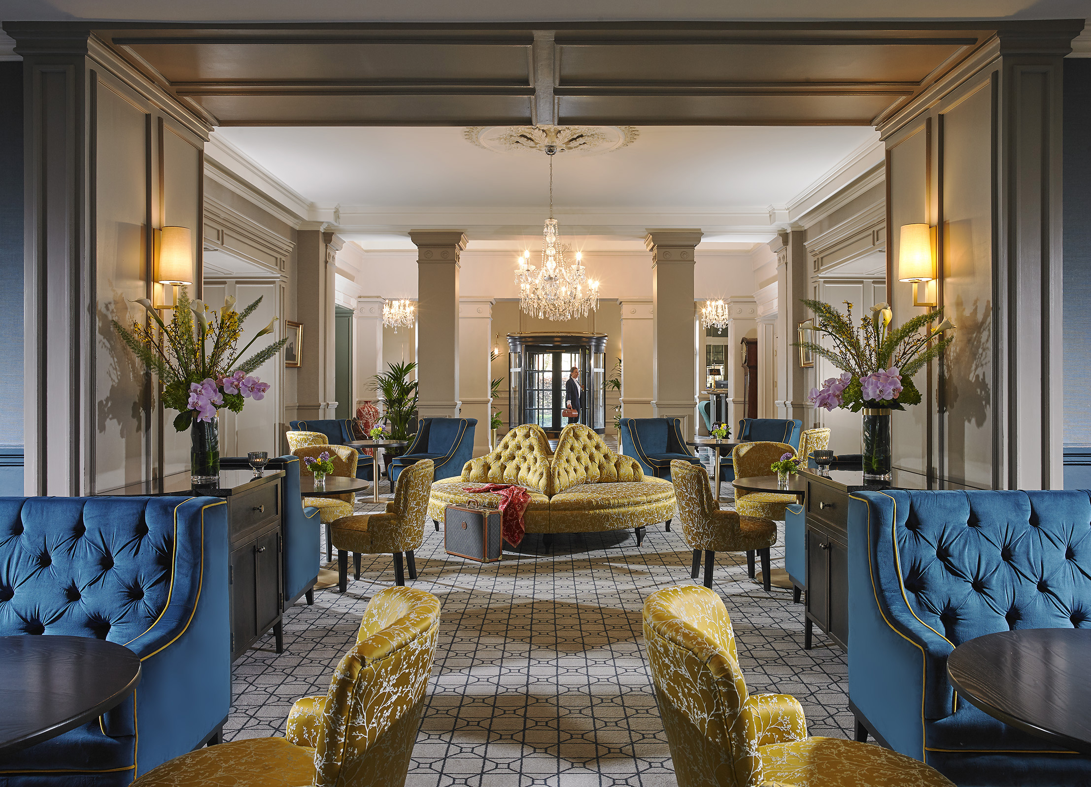 Lounge with yellow and blue sofas and chairs in The Hardiman hotel in Galway