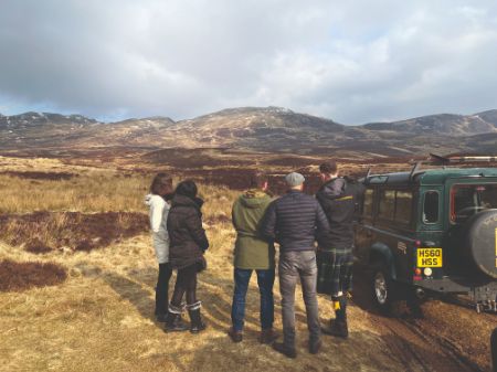 A group of people standing in front of a vehicle