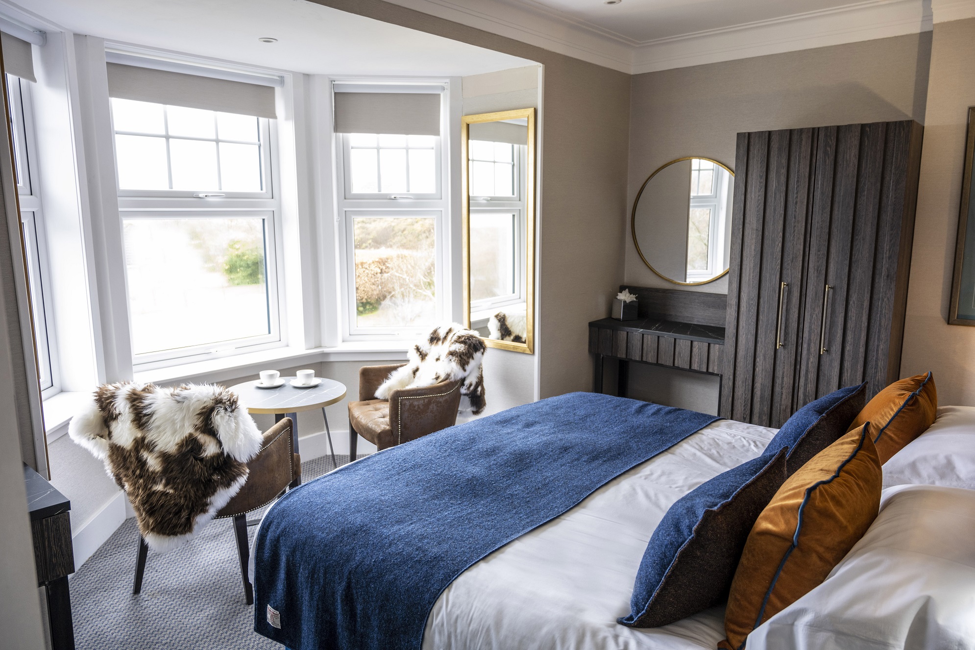 A bedroom with a large bed and two chairs