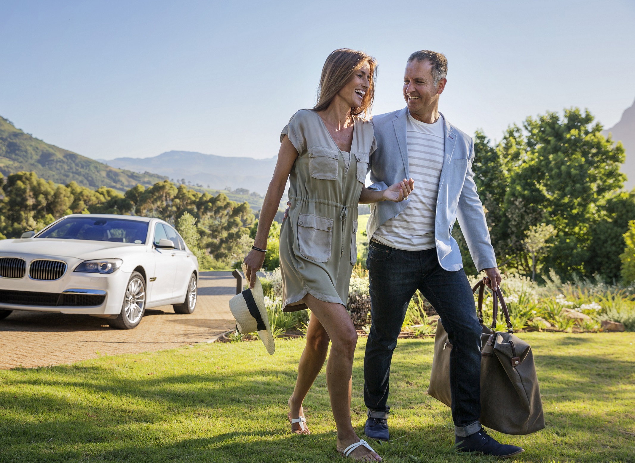 Confident couple arriving at home by car