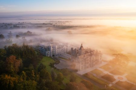 An aerial view of a castle surrounded by fog