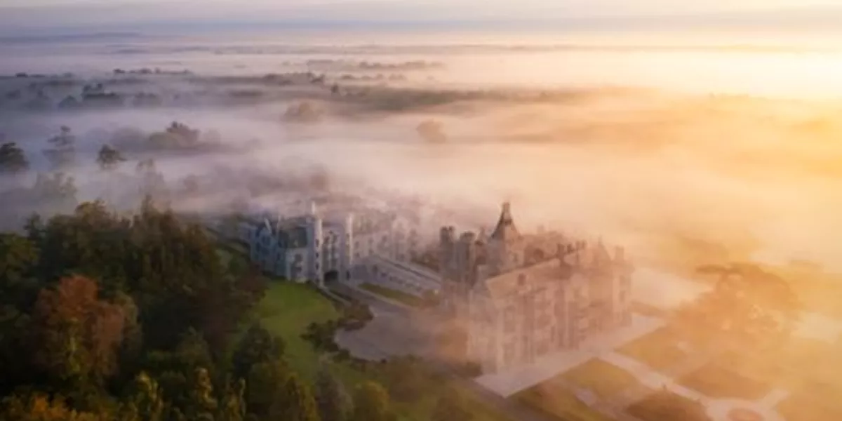 An aerial view of a castle surrounded by fog