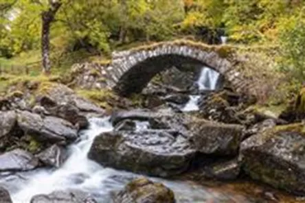 Low stone bridge with flowing stream