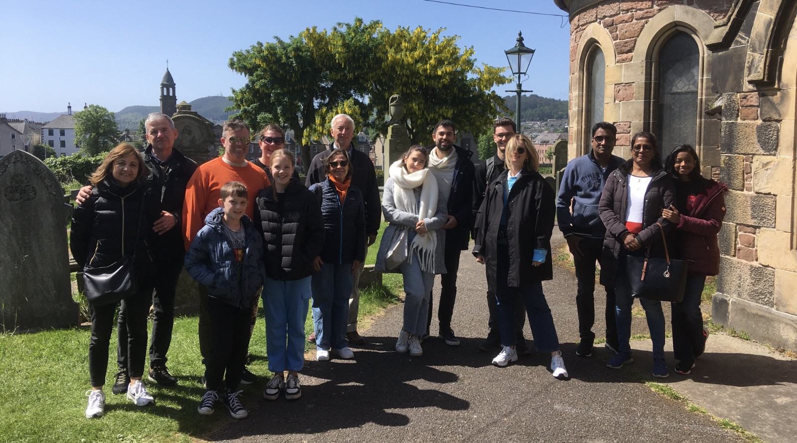 A group of people posing for a photo in front of a church in Inverness