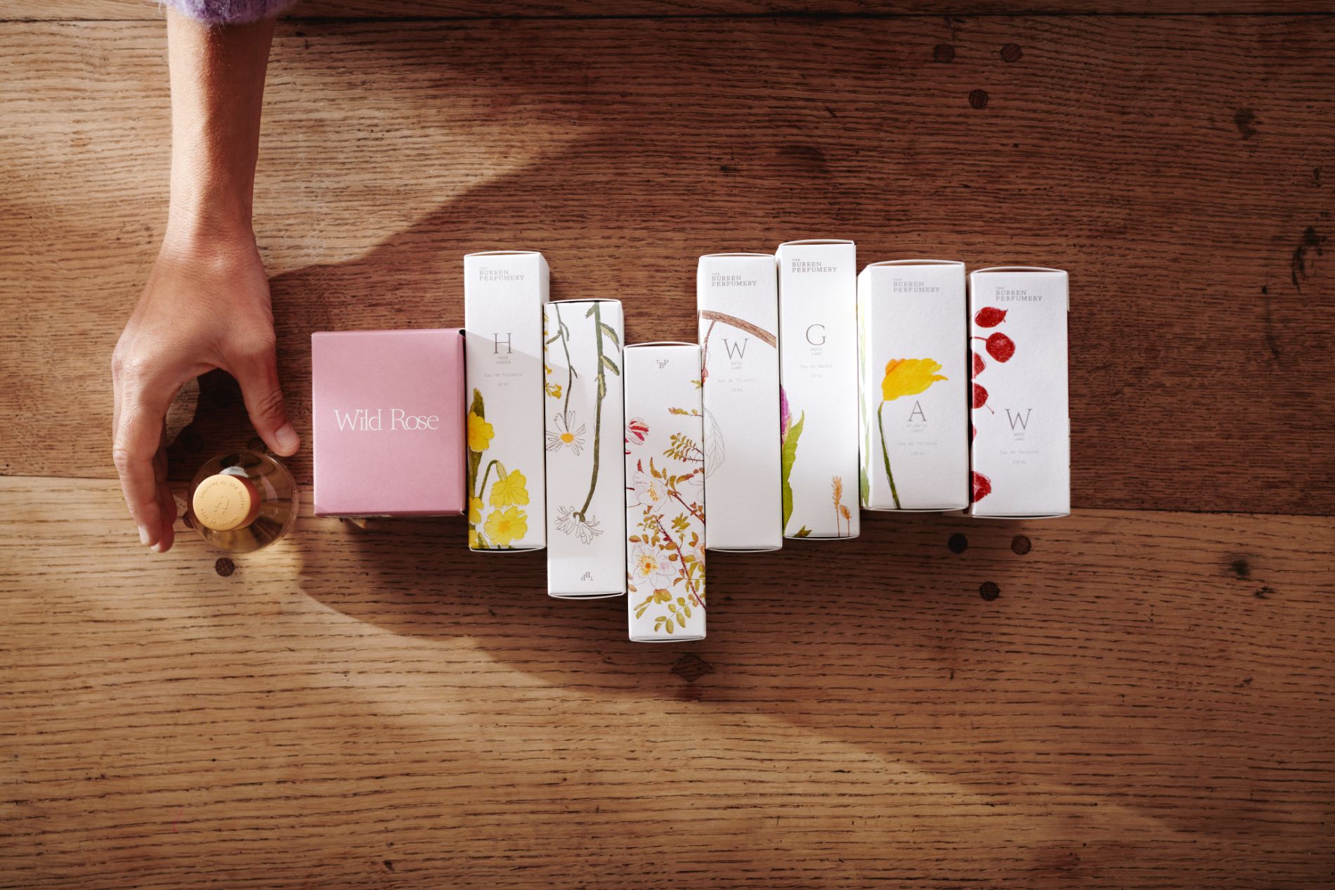 View on perfume set with person picking one up