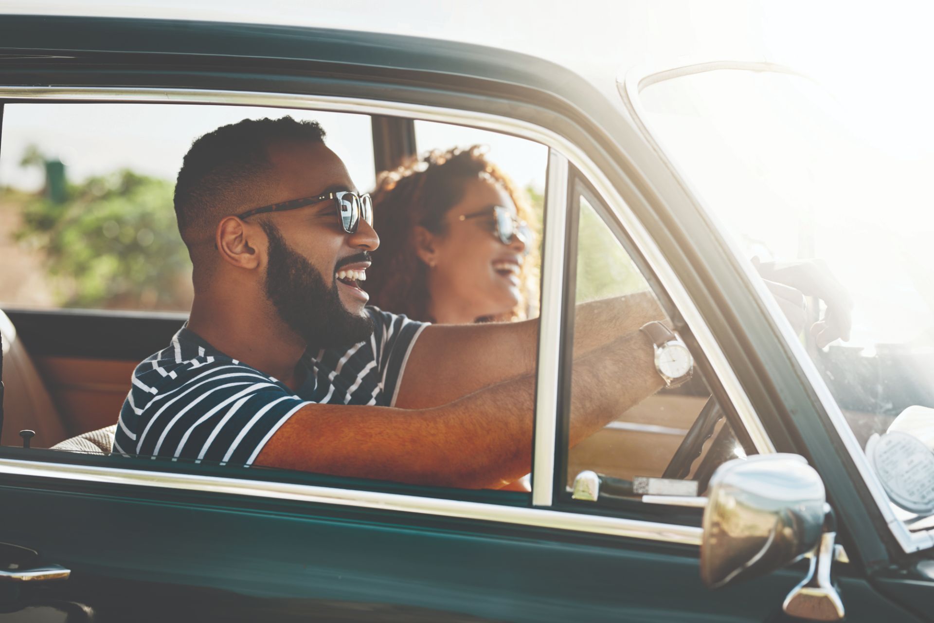 A man drives a car with a woman as a passenger on a self-drive road trip vacation.