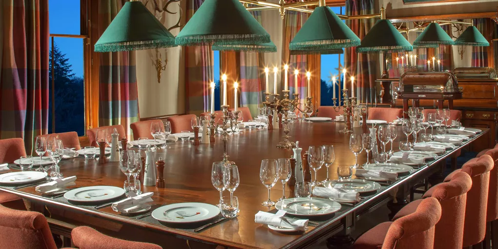 A dining room table with a lot of place settings